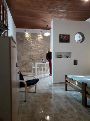 a woman standing in a room with a stone wall at Beach Studio next to the center in Kissamos