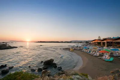 a beach with a group of umbrellas and chairs at Seafalios in Kalamaki Chanion