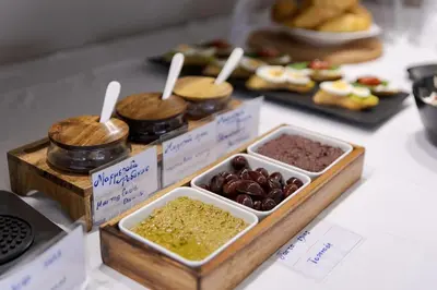 a table topped with trays of different types of food at Athina Beach Hotel in Kato Daratso