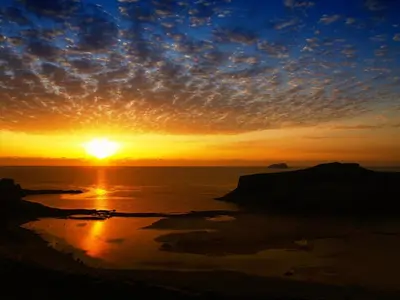 a sunset over the ocean with the sun in the sky at Villa Georgia Apartments & Suites in Kalamaki Chanion