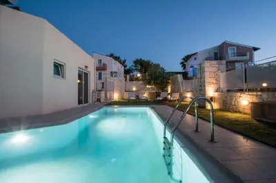 a swimming pool in front of a building at night at Pantanassa Villa Thalia in Agia Marina Nea Kydonias