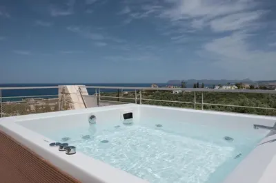 a hot tub on a balcony with a view of the ocean at Pantanassa Villa Thalia in Agia Marina Nea Kydonias