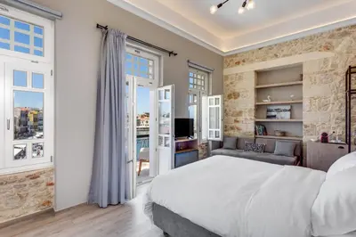 a bedroom with a large bed and a living room at 1924 suites in Chania Town
