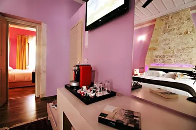 a bedroom with purple walls and a bed and a television at Elia Fatma Boutique Hotel in Chania Town