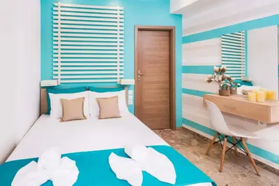 a small bedroom with a bed and a desk at Kalyves Maisonette Bougainvillea in Kalyves