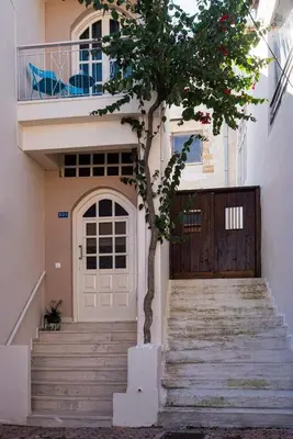 a tree in front of a house with a door at Kalyves Maisonette Bougainvillea in Kalyves