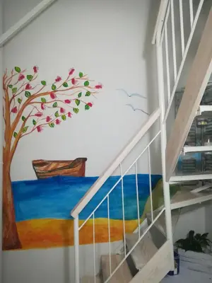 a mural of a tree on a wall next to a staircase at Kalyves Maisonette Bougainvillea in Kalyves