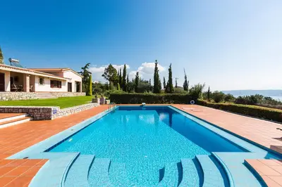 a swimming pool in front of a house at Villa Thealassa - Hanging Over the Sea by etouri in Kounoupidhianá