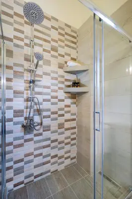 a shower in a bathroom with a wooden wall at Villa Thealassa - Hanging Over the Sea by etouri in Kounoupidhianá