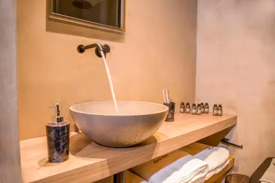 a bathroom with a bowl sink on a wooden counter at Portou House in Chania Town