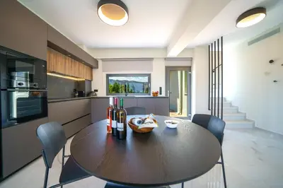 a kitchen with a table and chairs in a room at Mythic Olive villa - Heated Pool - Amazing view in Perivólia