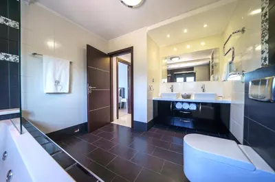 a bathroom with two sinks and a tub and a toilet at Mythic Olive villa - Heated Pool - Amazing view in Perivólia