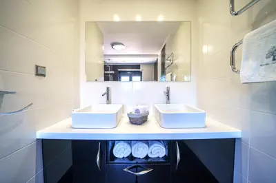 a bathroom with two sinks and a mirror at Mythic Olive villa - Heated Pool - Amazing view in Perivólia