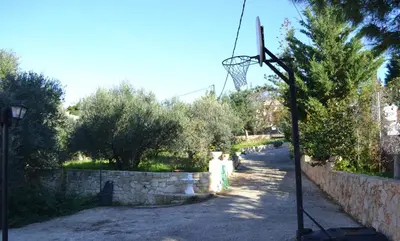 a basketball hoop in a yard with a stone wall at Rumpis Traditional House in Kambánion