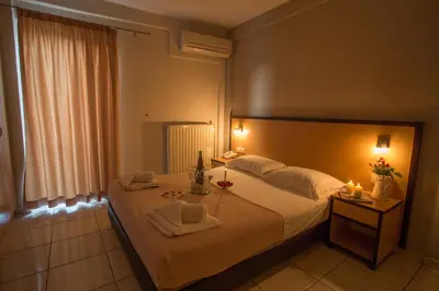 a bedroom with a large bed with candles on it at Theofilos City Hotel in Chania Town