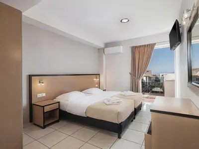 a hotel room with two beds and a window at Theofilos City Hotel in Chania Town