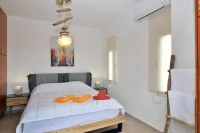 a bedroom with a bed with two red shoes on it at Villa Anva in Kato Daratso