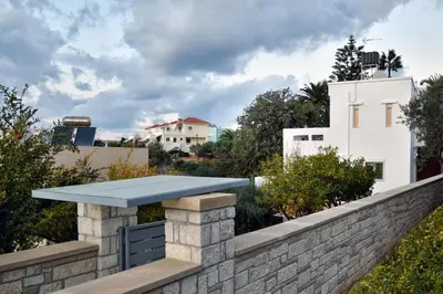 a stone wall with a blue roof on top of a building at Villa Anva in Kato Daratso