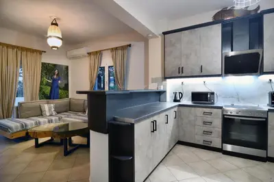 a kitchen and living room with a couch and a table at Villa Anva in Kato Daratso