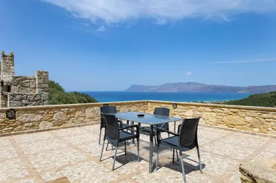 a table and chairs on a patio overlooking the ocean at Villa dimitris in Kissamos