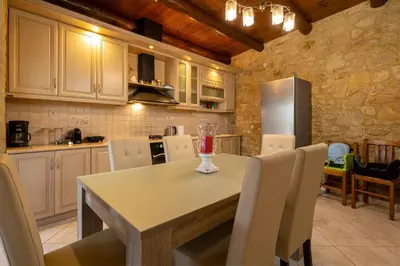 a kitchen with a table with chairs and a refrigerator at Villa dimitris in Kissamos