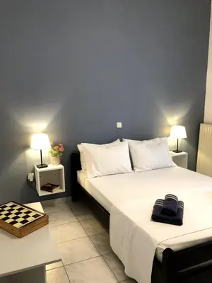 a bedroom with a large bed with two tables and two lamps at Rosy's House with all Amenities near Chania in Chania Town