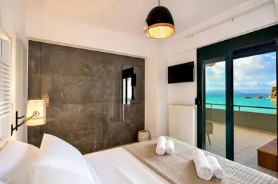a bedroom with a bed with a view of the ocean at Elia Beach in Chania Town