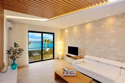 a living room with a white couch and a tv at Elia Beach in Chania Town