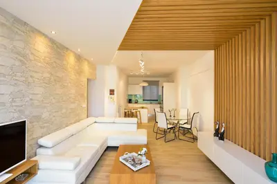 a living room with a white couch and a stone wall at Elia Beach in Chania Town