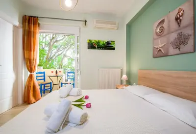a bedroom with a white bed with pillows and a window at Downtown Studio Chania in Chania Town