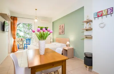a dining room with a table with pink flowers in a vase at Downtown Studio Chania in Chania Town