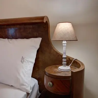 a lamp on a night stand next to a bed at Emmanouil’s House in Chania Town