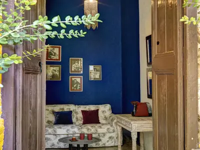 a living room with blue walls and a couch at Alcanea Boutique Hotel in Chania Town