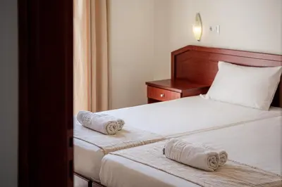 a bedroom with two beds with towels on them at Artemis Apartments in Stalos