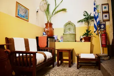 a living room filled with furniture and a yellow wall at Stoa Rooms in Chania Town