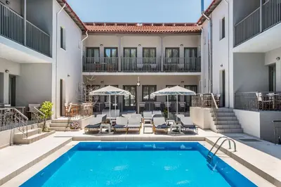an indoor pool with patio furniture and a building at Kiwi Apartments in Kato Daratso