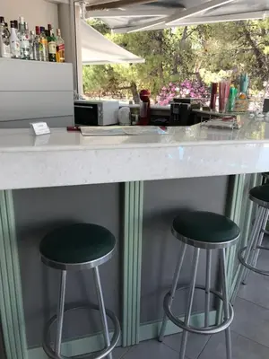 a counter with three green bar stools under it at Kiwi Apartments in Kato Daratso