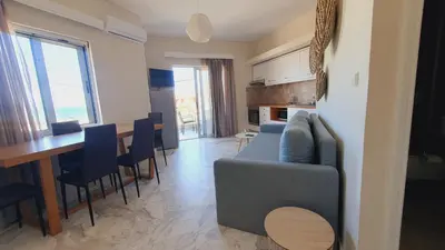 a living room with a blue couch and a table at Oliva Beach Hotel in Maleme