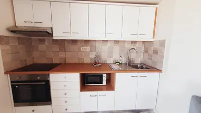 a kitchen with white cabinets and a sink at Oliva Beach Hotel in Maleme
