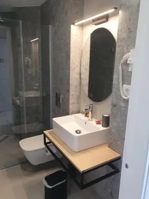 a bathroom with a white sink and a toilet at Oliva Beach Hotel in Maleme