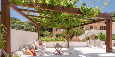 an outdoor patio with a pergola and a table at Feneri Traditional House Apt 1- 20' from Elafonisi beach in Elafonisi