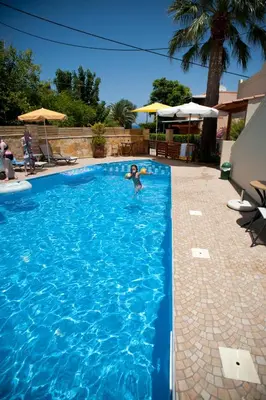 a person is swimming in a swimming pool at Nikolas Suites in Kato Daratso