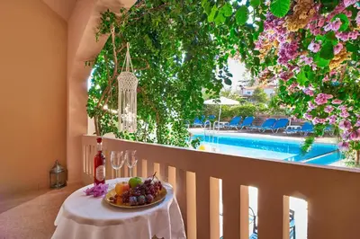 a table with a bowl of fruit on it with a view of a pool at Solon Apartments in Maleme