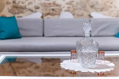 a glass bottle sitting on top of a glass table at Trigono Luxury House in Kissamos