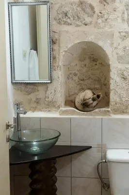 a bathroom with a glass sink and a mirror at Trigono Luxury House in Kissamos
