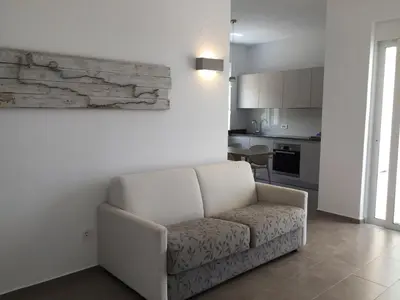 a living room with a couch and a kitchen at WeCrete Apartments in Drapaniás