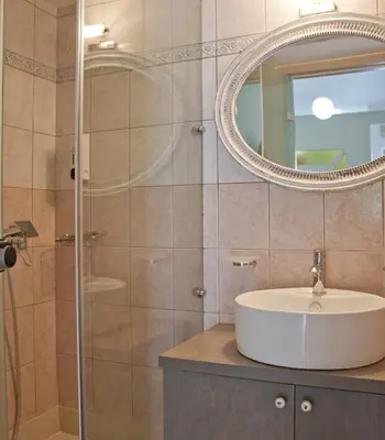a bathroom with a sink and a mirror at Hotel Christina in Chania Town
