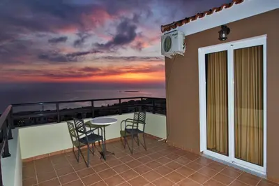 a balcony with a table and chairs and a view of the ocean at Nikos Apartments in Falasarna