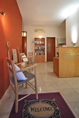 a living room with a table and chairs and a kitchen at Nikos Apartments in Falasarna