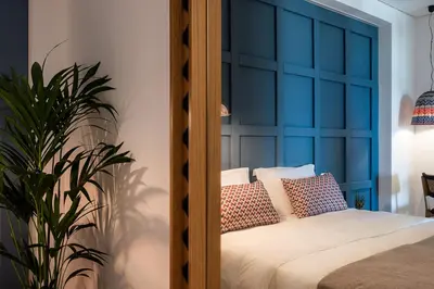 a bedroom with a bed with a blue headboard at Blue Island Luxury Apartment in Kato Daratso
